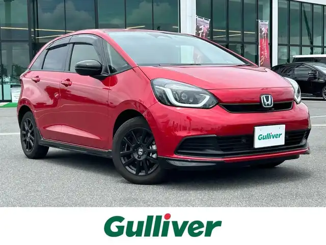 ホンダ フィット e:HEVホーム ブラックスタイル 奈良県 2024(令6)年 1.4万km プレミアムクリスタルレッドM 純正８インチディスプレイオーディオ　/ｂｌｕｅｔｏｏｔｈ　/applecaraplay/androidauto/リアワイドカメラ　/ＥＴＣ　/ハーフレザーシート　/ドライブレコーダー前後　/Hｏｎｄａｓｅｎｓｉｎｇ　/コーナーセンサー前後　/アダブティブクルーズコントロール/ブレーキホールド/LEDヘッドライト/オートライト/純正フロアマット/カーテンエアバッグ