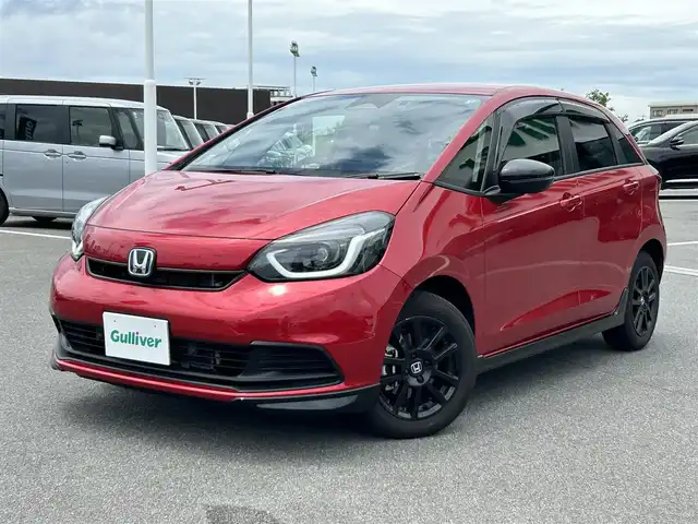 ホンダ フィット e:HEVホーム ブラックスタイル 奈良県 2024(令6)年 1.4万km プレミアムクリスタルレッドM 純正８インチディスプレイオーディオ　/ｂｌｕｅｔｏｏｔｈ　/applecaraplay/androidauto/リアワイドカメラ　/ＥＴＣ　/ハーフレザーシート　/ドライブレコーダー前後　/Hｏｎｄａｓｅｎｓｉｎｇ　/コーナーセンサー前後　/アダブティブクルーズコントロール/ブレーキホールド/LEDヘッドライト/オートライト/純正フロアマット/カーテンエアバッグ