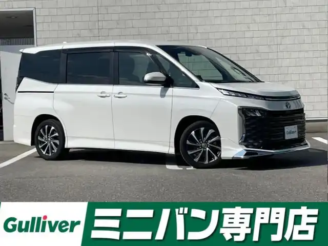 トヨタ ヴォクシー ハイブリッド S－Z 福岡県 2023(令5)年 1.7万km ホワイトパールクリスタルシャイン 純正ディスプレイオーディオナビ(フルセグTV/CD/DVD/BT)バックカメラコーナーセンサー両側パワスラクルコンドラレコETCシートヒーターブレーキホールドUSBHDMI純正フロアマット純正LED純正アルミホイールプッシュスタートスマートキーモデリスタエアロ