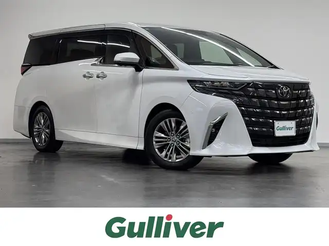 トヨタ アルファードハイブリット Z 三重県 2024(令6)年 0.9万km プラチナホワイトパールマイカ ハイブリッド/FF/MTモード付フロアCVT/14型ナビ/（FM/AM/TV/Bluetooth/USB/iPod/Miracast/CarPlay/AndroidAuto）/13.2型 有機EL後席モニター/パノラミックビューモニター（床下透過表示機能付）/両側パワースライドドア/ETC2.0/Toyota Safety Sense/●PCS、LTA、レーダークルコン、アダプティブハイビーム、RSA、プロアクティブドライビングアシスト、緊急操舵支援＋前後クロストラフィックアラート*/●パーキングサポートブレーキ/・BSM/LCA/安心降車アシスト/・アドバンスト・ドライブ/アドバンスト・パーク（リモート機能付*）/・ITS Connect*/など/装備/・デジタルインナーミラー*/・左右独立ムーンルーフ*/・合皮シート（ブラック）/・シートヒーター＆ベンチレーション（D/N/2nd）/・ステアリングヒーター/・パワーシート（Dメモリー付8way/N4way/2ndリクライニング＆オットマン）/・パワーバックドア/・ヘッドアップディスプレイ/・100Vコンセント（1500W）/・タッチトレーサーオペレーション/・3眼LEDヘッドランプ/・オートワイパー/・おくだけ充電/・17inAW/・保/・スマートキーx2/など/*…メーカーOP