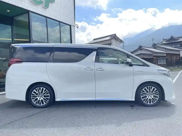 トヨタ アルファードハイブリット G Fパッケージ 愛媛県 2015(平27)年 9.8万km ラグジュアリーホワイトパールクリスタルシャインガラスフレーク 1オーナー/ツインサンルーフ/ALPINE専用10型ナビ【EX10】/　CD/DVD/Bluetooth/HDMI/フルセグTV/ガイド付きバックカメラ/ALPINE12.8型フリップダウンモニター/両側パワースライドドア/衝突被害軽減ブレーキ/クルーズコントロール/ステアリングヒーター/ベージュレザーシート/前席パワーシート(D席メモリー付)/前席シートヒーター/N席2列目オットマン/AC100Vアクセサリー/オートマチックハイビーム/オートライト/LEDヘッドライト/パワーバックドア/ビルトインETC/前後ドライブレコーダー/プッシュスタート/スペアキー×1/取説書
