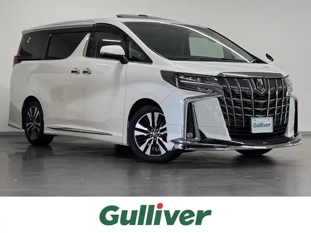 トヨタ アルファード S Cパッケージ 三重県 2020(令2)年 6.2万km ホワイトパールクリスタルシャイン ガソリン/FF/MTモード付インパネCVT/純正 9インチディスプレイオーディオ/（FM/AM/CD*/DVD*/USB/iPod/Bluetooth/Miracast）/12.1インチ 後席モニター V12T-R68C/バックガイドモニター/モデリスタエアロ（F/S/R下）＋スポーツマフラー/両側パワースライドドア/ドライブレコーダー 前後（ミラー内蔵）/ビルトイン ETC/Toyota Safety Sense/・プリクラッシュセーフティ/・レーントレーシングアシスト/・クリアランスソナー/・パーキングサポートブレーキ/・アダプティブハイビームシステム/・レーダークルコン/・ロードサインアシスト/・先行車発進告知機能/など/装備/・【OP】ツインムーンルーフ/・合皮シート/・パワーシート（D/N）/・エグゼクティブパワーシート（電動リクライニング＆オットマン（N/2nd））/・パワーバックドア/・シートヒーター・ベンチレーション（D/N）/・ステアリングヒーター/・オートライト/・3眼フルLEDヘッドランプ/・ステアリングスイッチ/・左右・後席独立オートエアコン/・自動防眩ルームミラー/・純正18inAW/・スマートキーx2/・保/取/・スペアタイヤ*/など/*…OP