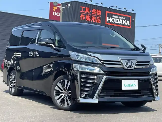 トヨタ ヴェルファイア ZG 道東・釧路十勝 2018(平30)年 2.4万km ブラック ４WD/Toyota Safety Sense/・PCS（プリクラッシュセーフティ）/・緊急時操舵支援/・レーンディパーチャーアラート/・ロードサインアシスト/・ドライバー異常時対応システム/・プロアクティブドライビングアシスト/・オートマチックハイビーム/・アダプティブハイビームシステム/・レーダークルーズコントロール/・先行車発進告知機能/社外メモリーナビ/（CD/DVD/BT)/フルセグTV/バックカメラ/両側パワースライドドア/パワーバックドア/クルーズコントロール/LEDオートライト/LEDフォグランプ/革シート/シートヒーター/パワーシート/エアシート/シートメモリ/純正室内カーテンセット/ステアリングヒーター/ステアリングスイッチ/電動オットマン/オートエアコン/アイドリングストップ/100V充電/電動化駆動ミラー/デジタルインナーミラー/スマートキー/社外ヒッチメンバー/ヘッドレストモニター/社外AW18インチ付きスタットレスタイヤ積込