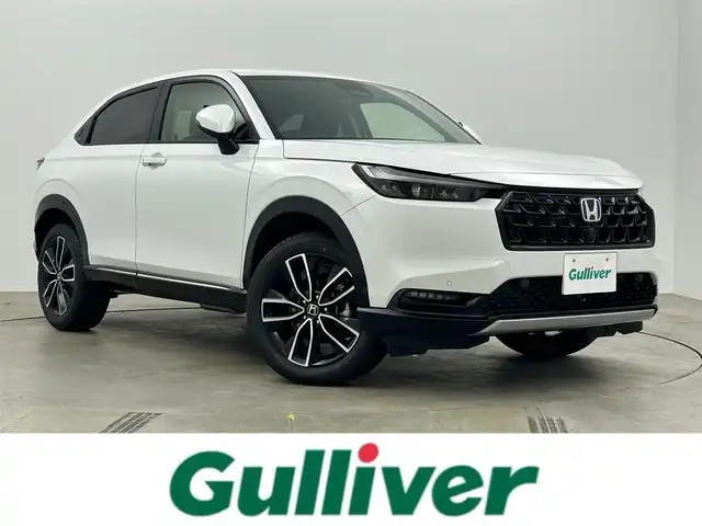 ホンダ ヴェゼル ハイブリッド e:HEV Z 岡山県 2025(令7)年 0.1万km未満 プラチナホワイトパール 登録済未使用車/Honda CONNECT９インチディスプレイオーディオ/（Bluetooth、フルセグTV、Carplay)/USB接続/レーダークルーズコントロール/LEDヘッドライト/ビルトインETC2.0/置くだけ充電/フロントグリル:ベルリナブラック/シートヒーター/ステアリングヒーター/ハーフレザー/ブラインドスポットモニター/パドルシフト/アイドリングストップ/チルトステアリング/シートリフター/ステアリングスイッチ/ISOFIX/純正リアスポイラー/バックカメラ/コーナーセンサー/踏み間違い防止/横滑り防止装置/スマートキー×2/新車保証書/取扱説明書