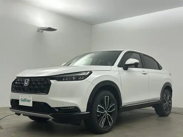 ホンダ ヴェゼル ハイブリッド e:HEV Z 岡山県 2025(令7)年 0.1万km未満 プラチナホワイトパール 登録済未使用車/Honda CONNECT９インチディスプレイオーディオ/（Bluetooth、フルセグTV、Carplay)/USB接続/レーダークルーズコントロール/LEDヘッドライト/ビルトインETC2.0/置くだけ充電/フロントグリル:ベルリナブラック/シートヒーター/ステアリングヒーター/ハーフレザー/ブラインドスポットモニター/パドルシフト/アイドリングストップ/チルトステアリング/シートリフター/ステアリングスイッチ/ISOFIX/純正リアスポイラー/バックカメラ/コーナーセンサー/踏み間違い防止/横滑り防止装置/スマートキー×2/新車保証書/取扱説明書