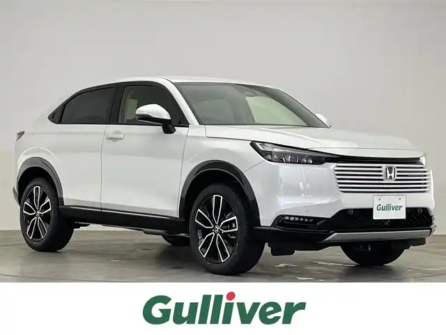 ホンダ ヴェゼル ハイブリッド e:HEV Z 滋賀県 2025(令7)年 0.1万km未満 プラチナホワイトパール 登録済未使用車/純正ナビ/（Bluetooth/USB/AppleCarPlay/AndroidAuto/フルセグTV）/バックカメラ/ビルトインETC/パワーバックドア/電動パーキングブレーキ/オートホールドブレーキ/路外逸脱抑制機能/ブラインドスポットインフォメーション/踏み間違い衝突軽減システム/衝突軽減ブレーキ/クリアランスソナー/革巻きステアリング/アダプティブクルーズコントロール/ステアリングヒーター/ステアリングリモコン/パドルシフト/ハーフレザーシート/シートヒーター/LEDヘッドライト/フォグランプ/オートヘッドライト/USB充電/置くだけ充電/カーテンエアバッグ/オートリトラーミラー/スペアキー