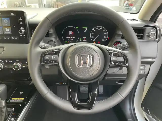 ホンダ ヴェゼル ハイブリッド e:HEV Z 滋賀県 2025(令7)年 0.1万km未満 プラチナホワイトパール 登録済未使用車/純正ナビ/（Bluetooth/USB/AppleCarPlay/AndroidAuto/フルセグTV）/バックカメラ/ビルトインETC/パワーバックドア/電動パーキングブレーキ/オートホールドブレーキ/路外逸脱抑制機能/ブラインドスポットインフォメーション/踏み間違い衝突軽減システム/衝突軽減ブレーキ/クリアランスソナー/革巻きステアリング/アダプティブクルーズコントロール/ステアリングヒーター/ステアリングリモコン/パドルシフト/ハーフレザーシート/シートヒーター/LEDヘッドライト/フォグランプ/オートヘッドライト/USB充電/置くだけ充電/カーテンエアバッグ/オートリトラーミラー/スペアキー