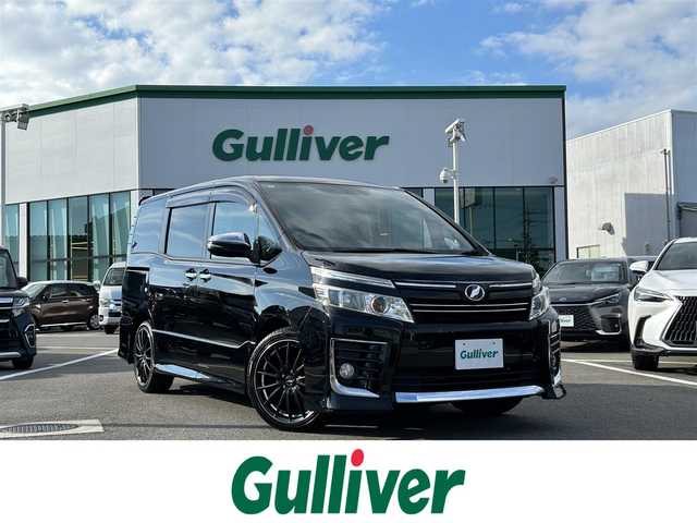 トヨタ ヴォクシー ZS 煌 愛媛県 2015(平27)年 7.7万km ブラック 登録時走行距離：76158km/メーカーオプション純正9inナビ/AM/FM/フルセグTV/Bluetooth/アルパインフリップダウンモニター/両側パワスラ/ビルトインETC/バックカメラ/追従クルコン/衝突軽減システム/横滑り防止装置/盗難防止装置/LEDヘッドライト/エンジンスタートボタン/スマートキー/スペアキー/社外アルミホイール/純正フロアマット