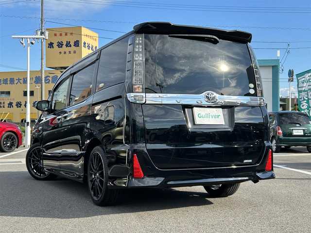 トヨタ ヴォクシー ZS 煌 愛媛県 2015(平27)年 7.7万km ブラック 登録時走行距離：76158km/メーカーオプション純正9inナビ/AM/FM/フルセグTV/Bluetooth/アルパインフリップダウンモニター/両側パワスラ/ビルトインETC/バックカメラ/追従クルコン/衝突軽減システム/横滑り防止装置/盗難防止装置/LEDヘッドライト/エンジンスタートボタン/スマートキー/スペアキー/社外アルミホイール/純正フロアマット