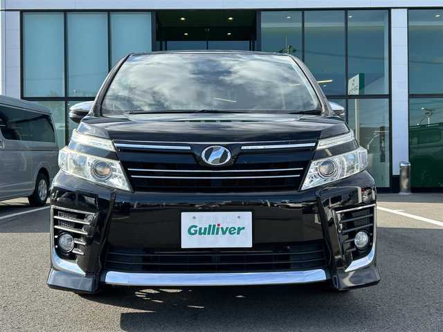 トヨタ ヴォクシー ZS 煌 愛媛県 2015(平27)年 7.7万km ブラック 登録時走行距離：76158km/メーカーオプション純正9inナビ/AM/FM/フルセグTV/Bluetooth/アルパインフリップダウンモニター/両側パワスラ/ビルトインETC/バックカメラ/追従クルコン/衝突軽減システム/横滑り防止装置/盗難防止装置/LEDヘッドライト/エンジンスタートボタン/スマートキー/スペアキー/社外アルミホイール/純正フロアマット