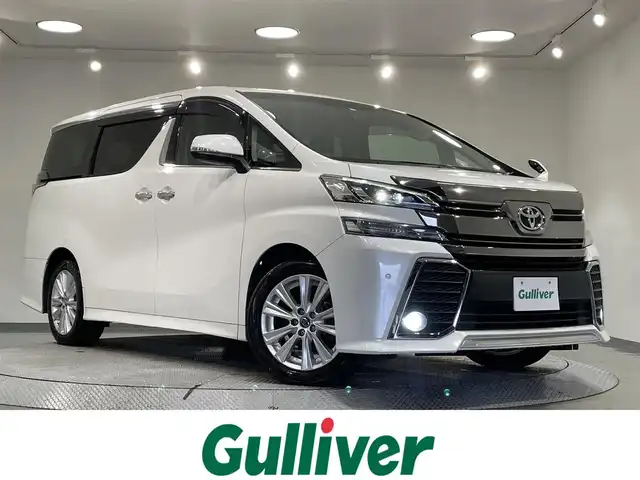 トヨタ ヴェルファイア Z 愛知県 2015(平27)年 6.2万km ホワイトパールクリスタルシャイン 純正９インチナビ　/（Bluetooth/フルセグTV/SD/CD・DVD再生/AM/FM)/１１インチフリップダウンモニター　/両側パワースライドドア　/ＡＣ１００Ｖ　/ビルトインＥＴＣ　/バックカメラ　　/ドライブレコーダー　/クリアランスソナー　/ＬＥＤヘッドライト/LEDフォグランプ/オットマン/プッシュスタート/　　-スマートキー/横滑り防止/アクセサリーソケット