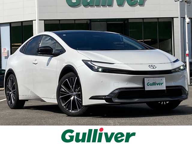 トヨタ プリウス Z 佐賀県 2023(令5)年 1.4万km プラチナホワイトパールマイカ ワンオーナー/パノラマルーフ/純正12.3インチディスプレイオーディオ/ナビキット/パノラマミックビューモニター/プリクラッシュセーフティ/レーンディパーチャーアラート/オートハイビーム/アダプティブクルーズコントロール/クリアランスソナー/ブラインドスポットモニター/リアクロストラフィックアラート/スマートルームミラー（前方録画機能付き）/置くだけ充電/電動パーキングブレーキ/オートブレーキホールド/パーキングアシスト/レザーシート/メモリパワーシートシート/シートヒーター/エアシート/パワートランク/ETC2.0/ステアリングヒーター/ステアリングリモコン/AC100V/プッシュスタート/スマートキー/LEDヘッドライト/純正アルミホイール