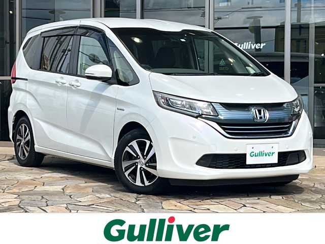 ホンダ フリード ハイブリット G ホンダセンシング 静岡県 2018(平30)年 9.2万km ホワイトオーキッドパール 【安全装備】/ホンダセンシング/アダプティブ・クルーズ・コントロール（ACC）/・作動車速域：約30km/hから100km/h間/車線維持支援システム（LKAS）/・作動車速：約65km/hから100km/h間/・ステアリング制御/衝突軽減ブレーキ（CMBS）/・歩行者検知機能/・作動車速：約80km/h未満時/・対向車車速：約30km/hから80km/h時/誤発進抑制機能（前進）/・ミリ波レーダー検知：作動車速10km/h未満/歩行者事故低減ステアリング/・作動車速10km/hから40km/h間/路外逸脱抑制機能/・作動車速：約60km/hから100km/h間/先行車発進お知らせ機能/標識認識機能/【主要装備】/純正ナビ　/フルセグ　/バックカメラ　/スマートキー　/プッシュスタート　/ＬＥＤヘッドライト　/両側パワースライドドア　/ハーフレザーシート　/ステアリングスイッチ　