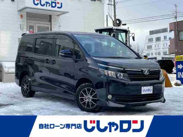 トヨタ ヴォクシー X 道央・札幌 2015(平27)年 12.1万km ブラッキッシュアゲハガラスフレーク (株)IDOMが運営する【じしゃロン札幌豊平店】の自社ローン対象車両になります。こちらは現金ご利用時の価格です。/自社ローンご希望の方は別途その旨お申付け下さい。/スマートキー/純正ナビ・TV/フリップダウンモニター/両側パワースライドドア/ETC/社外１５AW