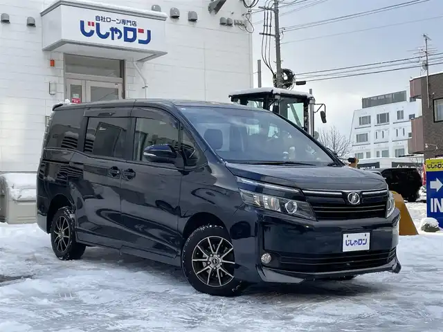 トヨタ ヴォクシー X 道央・札幌 2015(平27)年 12.1万km ブラッキッシュアゲハガラスフレーク (株)IDOMが運営する【じしゃロン札幌豊平店】の自社ローン対象車両になります。こちらは現金ご利用時の価格です。/自社ローンご希望の方は別途その旨お申付け下さい。/スマートキー/純正ナビ・TV/フリップダウンモニター/両側パワースライドドア/ETC/社外１５AW