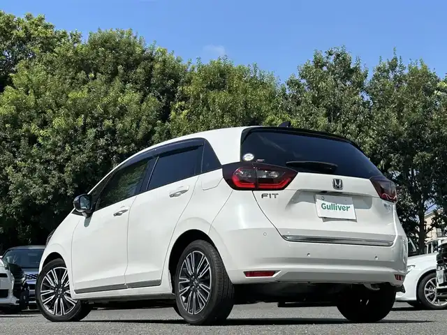 ホンダ フィット e:HEVリュクス 東京都 2020(令2)年 0.6万km プラチナホワイトパール ワンオーナー/純正9インチナビ（VXU-205FTi）/・フルセグTV/Bluetoothオーディオ/DVD/ワイヤレス充電器/バックカメラ/Honda SENSING/・衝突軽減ブレーキ〈CMBS〉/・誤発進抑制機能/・後方誤発進抑制機能/・近距離衝突軽減ブレーキ/・路外逸脱抑制機能/・渋滞追従機能付アダプティブ・クルーズ・コントロール/・車線維持支援システム/・オートハイビーム/合皮ハーフレザーシート/LEDヘッドライト/コンフォートビューパッケージ/ステアリングヒーター/純正16インチアルミホイール/保証書/取扱説明書/スペアキー