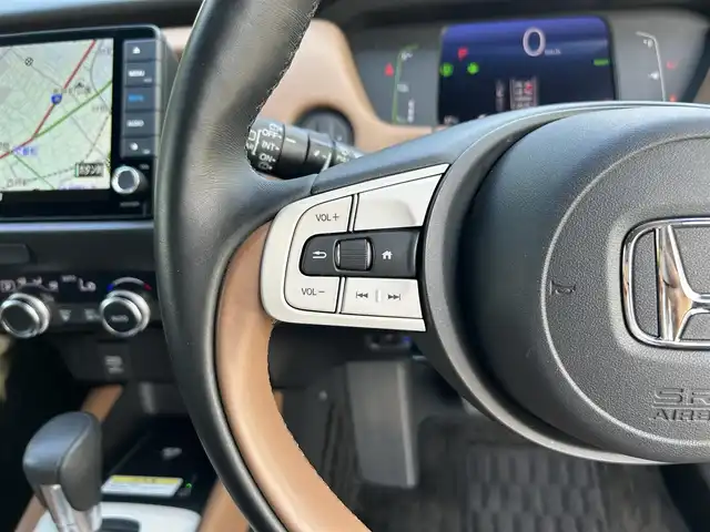 ホンダ フィット e:HEVリュクス 東京都 2020(令2)年 0.6万km プラチナホワイトパール ワンオーナー/純正9インチナビ（VXU-205FTi）/・フルセグTV/Bluetoothオーディオ/DVD/ワイヤレス充電器/バックカメラ/Honda SENSING/・衝突軽減ブレーキ〈CMBS〉/・誤発進抑制機能/・後方誤発進抑制機能/・近距離衝突軽減ブレーキ/・路外逸脱抑制機能/・渋滞追従機能付アダプティブ・クルーズ・コントロール/・車線維持支援システム/・オートハイビーム/合皮ハーフレザーシート/LEDヘッドライト/コンフォートビューパッケージ/ステアリングヒーター/純正16インチアルミホイール/保証書/取扱説明書/スペアキー