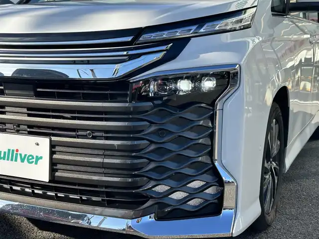トヨタ ヴォクシー ハイブリッド S－Z 福岡県 2022(令4)年 6万km ホワイトパールクリスタルシャイン ワンオーナー/純正10.5インチDA/純正14インチフリップダウンモニター/モデリスタシグネチャーイルミグリル/トヨタセーフティセンス/アドバンスドパーク/レーダークルーズコントロール/アラウンドビューモニター/ブラインドスポットモニター/プロアクティブドライビングアシスト/リアクロストラフィックアラート/リアカメラディテクション/パーキングサポートブレーキ/安心降車アシスト/ハンズフリーデュアルパワースライドドア/ロードサインアシスト/レーンチェンジアシスト/フロントクロストラフィックアラート/ヘッドアップディスプレイ/電動パーキングブレーキ/オートホールド/オートマチックハイビーム/前席＋後席シートヒーター/ハンドルヒーター/パワーバックドア/デジタルインナーミラー/前方ドラレコ/ETC2.0