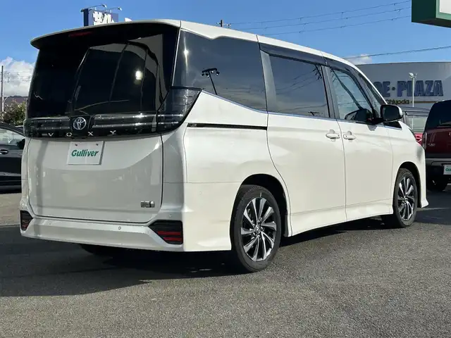 トヨタ ヴォクシー ハイブリッド S－Z 福岡県 2022(令4)年 6万km ホワイトパールクリスタルシャイン ワンオーナー/純正10.5インチDA/純正14インチフリップダウンモニター/モデリスタシグネチャーイルミグリル/トヨタセーフティセンス/アドバンスドパーク/レーダークルーズコントロール/アラウンドビューモニター/ブラインドスポットモニター/プロアクティブドライビングアシスト/リアクロストラフィックアラート/リアカメラディテクション/パーキングサポートブレーキ/安心降車アシスト/ハンズフリーデュアルパワースライドドア/ロードサインアシスト/レーンチェンジアシスト/フロントクロストラフィックアラート/ヘッドアップディスプレイ/電動パーキングブレーキ/オートホールド/オートマチックハイビーム/前席＋後席シートヒーター/ハンドルヒーター/パワーバックドア/デジタルインナーミラー/前方ドラレコ/ETC2.0