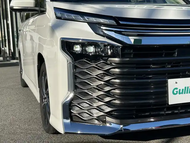 トヨタ ヴォクシー ハイブリッド S－Z 福岡県 2022(令4)年 6万km ホワイトパールクリスタルシャイン ワンオーナー/純正10.5インチDA/純正14インチフリップダウンモニター/モデリスタシグネチャーイルミグリル/トヨタセーフティセンス/アドバンスドパーク/レーダークルーズコントロール/アラウンドビューモニター/ブラインドスポットモニター/プロアクティブドライビングアシスト/リアクロストラフィックアラート/リアカメラディテクション/パーキングサポートブレーキ/安心降車アシスト/ハンズフリーデュアルパワースライドドア/ロードサインアシスト/レーンチェンジアシスト/フロントクロストラフィックアラート/ヘッドアップディスプレイ/電動パーキングブレーキ/オートホールド/オートマチックハイビーム/前席＋後席シートヒーター/ハンドルヒーター/パワーバックドア/デジタルインナーミラー/前方ドラレコ/ETC2.0