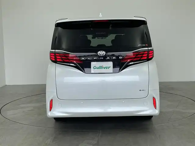 トヨタ アルファードハイブリット Z 愛知県 2023(令5)年 3.7万km プラチナホワイトパールマイカ メーカー14インチDA/（AM/FM/BT/フルセグTV）/13.2型有機EL後席ディスプレイ/全方位バックカメラ/合皮シート/前席パワーシート/前席＋二列目シートベンチレーション/前席＋二列目シートヒーター/ステアリングヒーター/前後ドラレコ/電動リアゲート/置くだけ充電/ユニバーサルステップ/トヨタセーフティセンス/・プリクラッシュセーフティ/・レーンキープアシスト/・ブラインドスポットモニター/・レーダークルーズコントロール/・クリアランスソナー/・ロードサインアシスト/・パーキングアシスト/・オートマチックハイビーム/100V電源/エコモード/EVモード/純正18AW/純正フロアマット/ドアバイザー/オートブレーキホールド/nanoeX/カーテンエアバッグ