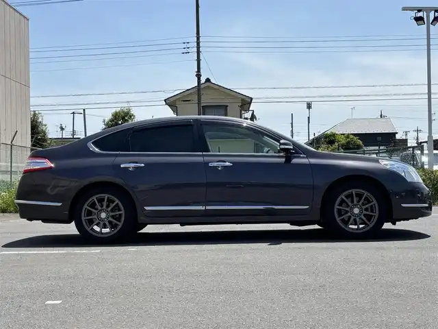 日産 ティアナ 250XL 東京都 2012(平24)年 9.9万km ディープアメジストグレー VDC/TCS/メッキ加飾横３本バーフロントグリル/開口部無塗装１本桟フロントバンパー/ボディ同色電動格納ミラー/ウィンカーミラー/リア標準バンパー/木目調加飾シルキーエクリュインパネ/ファインビジョンメーター（自発光式アナログメーター）/シルキーエクリュ革巻きステアリングホイール/SRSエアバック （運転席/助手席/サイド）/左右独立温度調整オートエアコン/後席エアコン吹出口/シルキーエクリュシート/パワーシート（運転席/助手席）パワーオットマン （助手席）/シート別体上下調整式ヘッドレスト（後席左右中央）/木目調カップホルダー付きアームレスト（後席中央）/インテリジェントキー/イモビライザー/プッシュエンジンスターター/７インチ液晶モニター/スーパーサウンドシステム１（６CD/６スピーカー）/バックモニター