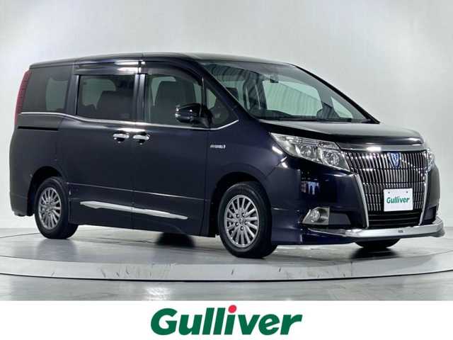 トヨタ エスクァイア ハイブリッド Gi 佐賀県 2015(平27)年 9.4万km スパークリングブラックパールクリスタルシャイン 純正９インチナビ【NSZT-Y64T】/（フルセグTV/CD/DVD/SD/BT/AM・FM）/純正１１インチ後席モニター/モデリスタエアロ（フロント・サイド・リアアンダー）/バックカメラ/衝突被害軽減システム/前後ドライブレコーダー/ハーフレザーシート/両側パワースライドドア/クルーズコントロール/ビルトインＥＴＣ/純正アルミホイール/純正フロアマット/純正LEDヘッドライト/オートライト/スペアキー×１