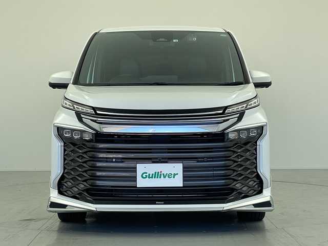 トヨタ ヴォクシー ハイブリッド S－Z 愛知県 2022(令4)年 2.1万km ホワイトパールクリスタルシャイン 純正ディスプレイオーディオ/・Bluetooth接続/・フルセグ/・AppleCarplay/AndroidAuto/・CD/快適利便パッケージ（Ｈｉｇｈ）/・ハンズフリーデュアルパワースライドドア（挟み込み防止機能付）/・パワーバックドア（挟み込み防止機能/停止位置メモリー機能/パワーバックドアスイッチ〈車両サイド〉付）/・ステアリングヒーター/・キャプテンシート/パノラミックビューモニター/ビルトインＥＴＣ2.0/前後型ドライブレコーダー/前席、２列目シートヒーター/トヨタセーフティセンス/・プリクラッシュセーフティ/・レーダークルーズコントロール/・RCTA（リアクロストラフィックディテクション）/・踏み間違い防止/・レーンキープアシスト/パーキングアシスト/LEDオートライト/オートハイビーム/100V充電/前後コーナーセンサー/純正フロアマット/純正アルミホイール/モデリスタフルエアロ