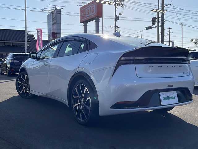 トヨタ プリウス Z 山口県 2023(令5)年 2.5万km プラチナホワイトパールマイカ 純正メモリナビ/（フルセグTV/Bluetooth/Miracast）/純正12.3型ディスプレイオーディオ/アラウンドビューモニター/クルーズコントロール/ブラインドスポットモニター/パーキングアシスト/レザーシート/シートヒーター（D/N席）/D席シートメモリ/ステアリングヒーター/パワーバックドア/ETC2.0/GRフロントスポイラー/GRテールゲートスポイラー/純正19インチアルミホイール/純正フロアマット