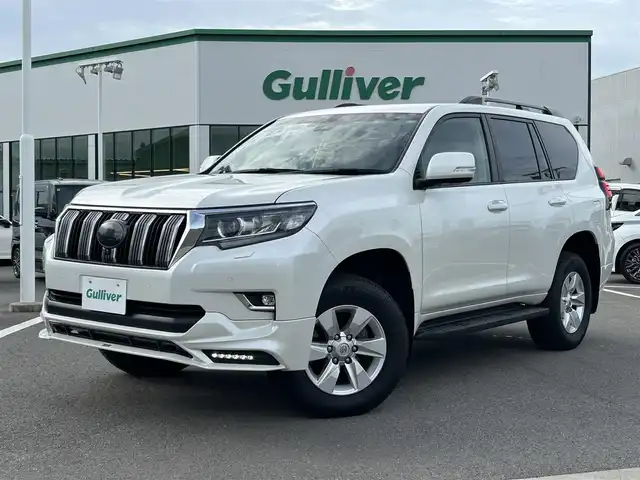 トヨタ ランドクルーザー プラド TX Lパッケージ 愛媛県 2023(令5)年 2.1万km ホワイトパールクリスタルシャイン 登録時走行距離：20800km/メーカーオプション純正メモリナビ/AM/FM/フルセグTV/Bluetooth/ETC/電動サードシート/パドルシフト/追従クルコン/レザーシート/シートヒーター/エアシート/衝突軽減システム/横滑り防止装置/盗難防止装置/レーンキープアシスト/LEDヘッドライト/オートライト/オートハイビーム/エンジンスタートボタン/スマートキー/スペアキー/純正アルミホイール/社外フロアマット
