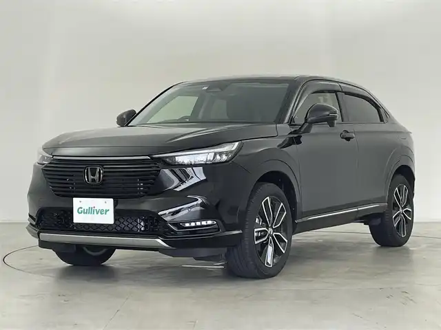 ホンダ ヴェゼル ハイブリッド e:HEV Z 群馬県 2023(令5)年 1.4万km クリスタルブラックパール 純正9インチナビ/(AM/FM/Bluetooth/CD/DVD/SD/USB)/＝＝＝＝＝＝/バックモニター/ブラインドスポットインフォメーション/ハンズフリーアクセスパワーテールゲート(予約クローズ機能付)/Honda SENSING/ ・衝突軽減ブレーキ/近距離衝突軽減ブレーキ/ ・誤発進抑制機能/後方誤発進抑制機能/ ・歩行者事故低減ステアリング/ ・路外逸脱抑制機能/ ・渋滞追従機能付アダプティブクルーズコントロール/ ・車線維持支援システム/ ・トラフィックジャムアシスト/ ・先行車発進お知らせ機能/ ・標識認識機能/ ・オートハイビーム/ ・パーキングセンサーシステム/パドルシフト/前席シートヒーター/ステアリングヒーター/純正前後方ドライブレコーダー/ETC/親水/ヒーテッドドアミラー/電熱線入りフロントウィンドウ/電動パーキングブレーキ/オートブレーキホールド/プッシュスタート/スマートキー