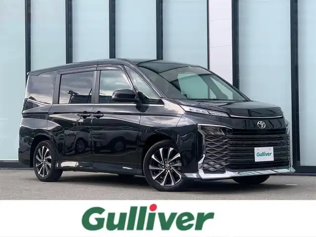 トヨタ ノア ハイブリッド Si ダブルバイビーⅡ 大阪府 2019(令1)年 3.3万km ブラッキッシュアゲハガラスフレーク 社外９インチナビ/   フルセグTV/CD/DVD/Bluetooth/USB/バックモニター/１０．１インチ後席モニター/（登録時走行距離 32629km）/衝突軽減ブレーキ/横滑り防止装置/前席シートヒーター/クルーズコントロール/両側パワースライドドア/ドライブレコーダー/ハーフレザーシート/オートマチックハイビーム/純正16インチアルミホイール/コーナーセンサー/プッシュスタート/スマートキー/ＥＴＣ/ＬＥＤライト