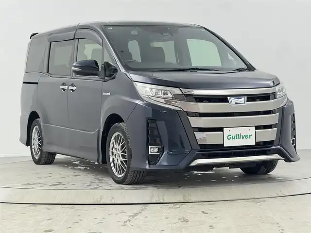 トヨタ ノア ハイブリッド Si ダブルバイビーⅡ 熊本県 2019(令1)年 3.3万km ブラッキッシュアゲハガラスフレーク 社外９インチナビ/   フルセグTV/CD/DVD/Bluetooth/USB/バックモニター/１０．１インチ後席モニター/（登録時走行距離 32629km）/衝突軽減ブレーキ/横滑り防止装置/前席シートヒーター/クルーズコントロール/両側パワースライドドア/ドライブレコーダー/ハーフレザーシート/オートマチックハイビーム/純正16インチアルミホイール/コーナーセンサー/プッシュスタート/スマートキー/ＥＴＣ/ＬＥＤライト