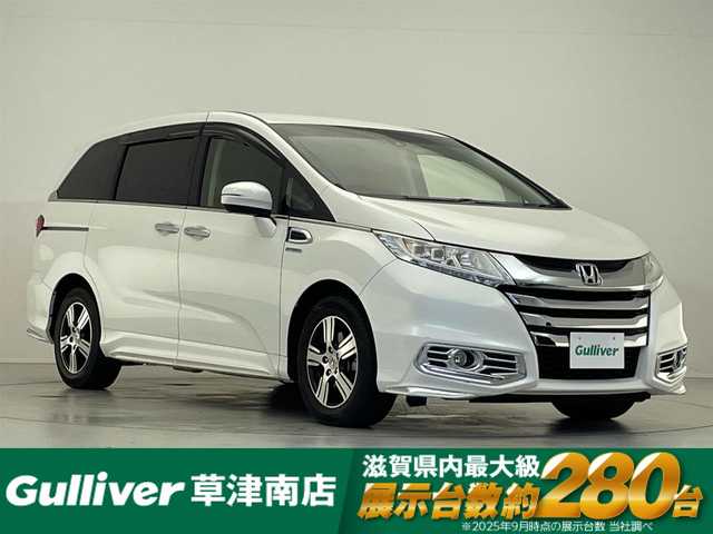 ホンダ オデッセイ ハイブリッド EX　パッケージ 滋賀県 2016(平28)年 7.1万km ホワイトオーキッドパール 社外7インチナビ/【Bluetooth/DVD/CD/フルセグTV】/両側パワースライドドア/ホンダセンシング/・衝突軽減ブレーキ 〈CMBS〉/・歩行者事故低減ステアリング/・アダプティブクルーズコントロール/・LKAS 〈車線維持支援システム〉/・路外逸脱抑制機能/・誤発進抑制機能/・先行車発進お知らせ機能/・標識認識機能/バックカメラ/純正フリップダウンモニター/AC100V電源/ビルトイン純正ETC/LEDヘッドライト/エンジンスターター/純正フロアマット/D席パワーシート/コンフォートビューパッケージ/二列目オットマン/ステアリングリモコン/スマートキー/プッシュスタート