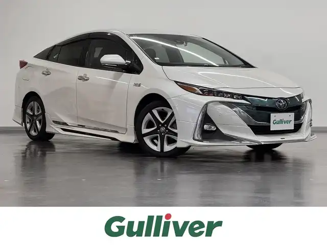 トヨタ プリウス ＰＨＶ A プレミアム 三重県 2018(平30)年 5.4万km ホワイトパールクリスタルシャイン プラグインハイブリッド/FF/インパネCVT/純正 11.6インチ 縦型ナビ/（AM/FM/USB/iPod/Bluetooth/AUX/TV）/バックカメラ/モデリスタエアロ（F/S/R下）/【OP】ETC2.0/Toyota Safety Sense/・プリクラッシュセーフティ/・レーンディパーチャーアラート（操舵支援付）/・レーダークルコン/・オートハイビーム/・ふらつき検知機能/・ブラインドスポットモニター/・インテリジェントクリアランスソナー（巻き込み警報機能付）/・シンプルインテリジェントパーキングアシスト/など/装備/・本革シート/・シートヒーター（D/N）/・ステアリングヒーター/・カラーヘッドアップディスプレイ/・AC100Vアクセサリーコンセント（ヴィークルパワーコネクター付・V2H対応・コンセント2ヶ）/・オートエアコン/・オートライト/・4灯 LEDヘッドライト＆LED フロントフォグランプ/・【OP】純正17inAW/・ステアリングスイッチ/・プッシュスタート/・スマートキーx2/・保/取/ナビ取/・充電ケーブル（AC200V用・7m）/など