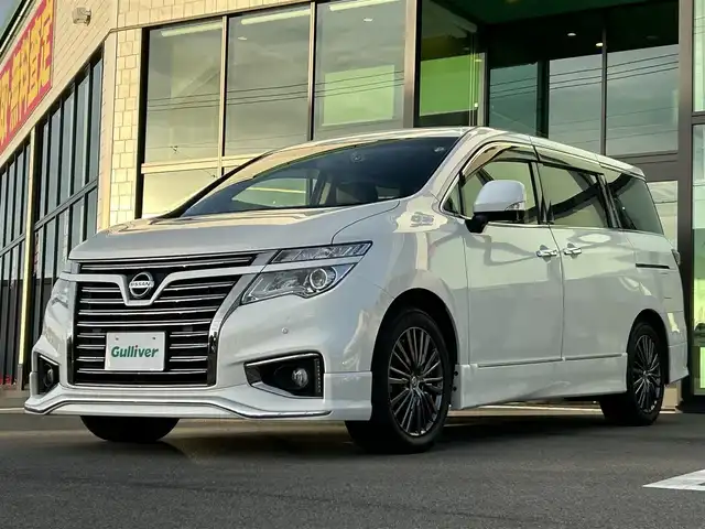 日産 エルグランド 250HWS アーバンクロム 愛媛県 2015(平27)年 7.9万km ブリリアントホワイトパール 純正ナビ/CD/DVD/Bluetooth/ワンセグ/全周囲/バックカメラ/ビルトインETC/リアエンターテインメント/両側パワースライドドア/ハーフレザーシート/クルーズコントロール/前方ドライブレコーダー/プッシュスタート/オートライト/HIDヘッドライト/バックドアイージークローザー/ウッドコンビステアリング/ニスモマフラー/電動格納ミラー/フロアマット/純正18インチAW/AC100Vコンセント