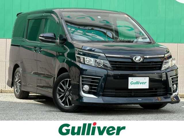 トヨタ ヴォクシー ZS 千葉県 2015(平27)年 7.8万km ブラッキッシュアゲハガラスフレーク 純正９インチメモリナビ/CD/DVD/Bluetooth/フルセグ/純正フリップダウンモニター/モデリスタエアロ/両側パワースライドドア/バックカメラ/ドアバイザー/ドライブレコーダー/ビルトインETC/純正１６インチAW/純正フロアマット/プッシュスタート/スマートキー
