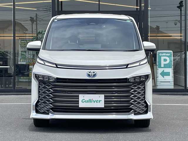 トヨタ ヴォクシー ハイブリッド S－Z 茨城県 2023(令5)年 0.9万km ホワイトパールクリスタルシャイン 純正ナビ/【AM・FM・TV・BT・USB・ＣＤ・ＤＶＤ】/快適利便パッケージHigh/ハンズフリーデュアルパワースライドドア（挟み込み防止機能付）/パワーバックドア（挟み込み防止機能・停止位置メモリー機能・パワーバックドアスイッチ〈車両サイド〉付）/ナノイーX/ステアリングヒーター/キャプテンシート追加機能：シートヒーター、オットマン（2WD車のみ）、角度調整付アームレスト（2WD車のみ）/電動リアゲート/両側パワスラ/BSM/HUD/デジタルインナーミラー/レーダークルコン/Ｂカメラ/ETC2.0/前方ドラレコ/前後コーナーセンサー/ブレーキホールド/100V電源
