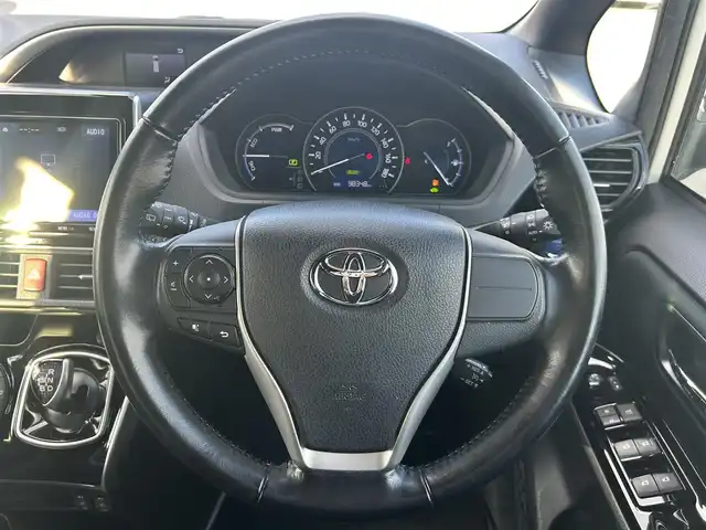 トヨタ ヴォクシー ハイブリッド ZS 煌 岡山県 2018(平30)年 9.9万km ホワイトパールクリスタルシャイン 登録時走行距離98348km/TRDエアロ/純正9インチナビ/フルセグTV(AM.FM.CD.DVD.TV.BT)/両側パワースライドドア/バックカメラ/ETC/シートヒーター/クリアランスソナー/衝突軽減ブレーキ/横滑り防止装置/クルーズコントロール/車線逸脱警報（レーンキープアシスト）/オートライト/オートマチックハイビーム/アイドリングストップ/16インチ純正AW/純正フロアマット/スペアキー/LEDヘッドライト/取扱説明書