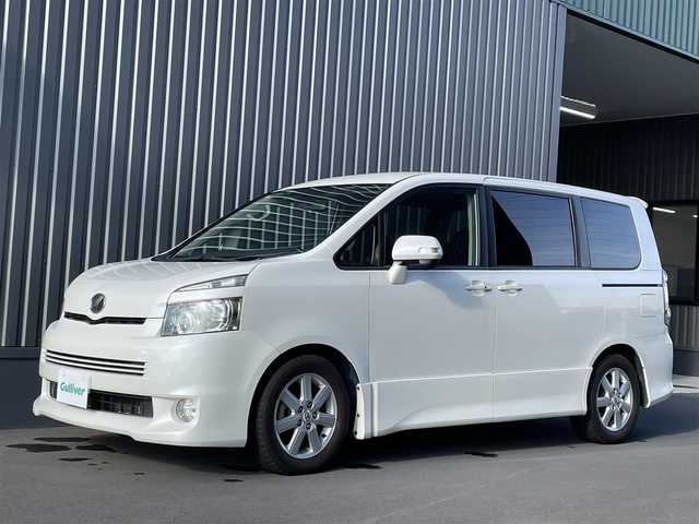 トヨタ ヴォクシー ZS 佐賀県 2008(平20)年 10.5万km ホワイトパールクリスタルシャイン 純正ディーラーオプションナビ（NHZN-W57）/CD/DVD/フルセグTV/バックカメラ/アルパイン製　10.2インチ　フリップダウンモニター/両側パワースライドドア/ETC/パドルシフト/MTモード付AT/デュアルオートエアコン/キセノンライト/フォグランプ/電動格納ミラー/純正アルミホイール/フロアマット/プッシュスタート/スマートキー