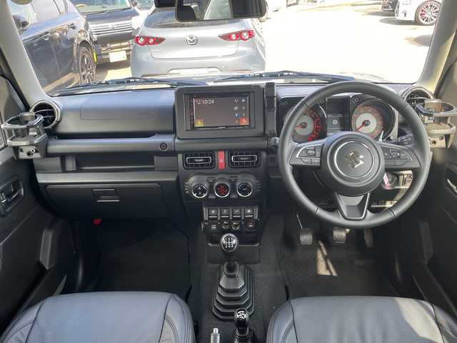 スズキ ジムニー XC 大阪府 2024(令6)年 1.1万km ミディアムグレー ＤＡＭＤグリル/カヤバショックアブソーバー/アピオ16インチアルミホイール/ボンネットダンパー/黒革調シートカバー/ラバーフロアマット/ディスプレイオーディオ/CD/BT/USB/バックカメラ/ドライブレコーダー/衝突軽減システム/レーンキープアシスト/クルーズコントロール/LEDヘッドライト/オートライト/ヒーテッドドアミラー/ヘッドライトウォッシャー/取説/保証書/スペアキーｘ１