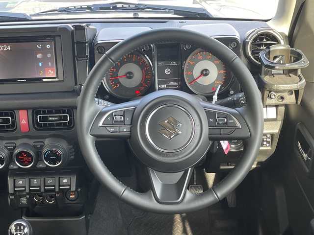 スズキ ジムニー XC 大阪府 2024(令6)年 1.1万km ミディアムグレー ＤＡＭＤグリル/カヤバショックアブソーバー/アピオ16インチアルミホイール/ボンネットダンパー/黒革調シートカバー/ラバーフロアマット/ディスプレイオーディオ/CD/BT/USB/バックカメラ/ドライブレコーダー/衝突軽減システム/レーンキープアシスト/クルーズコントロール/LEDヘッドライト/オートライト/ヒーテッドドアミラー/ヘッドライトウォッシャー/取説/保証書/スペアキーｘ１