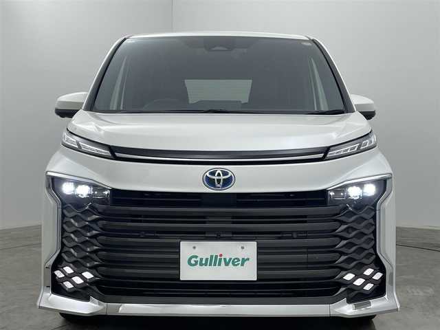 トヨタ ヴォクシー ハイブリッド S－Z 岡山県 2024(令6)年 1.4万km ホワイトパールクリスタルシャイン メーカーオプション/・純正10.5インチディスプレイオーディオプラス/　車載ナビ Bluetooth USB AppleCarPlay /   AndroidAuto/・パノラミックビューモニター/・パーキングアシスト /・プロジェクター式LEDヘッドライト/・快適利便パッケージhigh/　パワーバックドア/　２列目シートヒーター/オットマン/・DVD/CD/地デジ/HDMI/ディーラーオプション/・純正13.1インチフリップダウンモニター/・ETC2.0ユニット/・ALPINE12インチデジタルミラー /・シートヒーター/・ステアリングヒーター/・トヨタセーフティセンス/　レーダークルーズコントロール/　プリクラッシュセーフティ/　レーンキープアシスト/　誤発進抑制/　オートハイビーム /・GRドアプロテクター/・両側パワースライドドア /・クリアランスソナー/・プッシュスタート /・スマートキー/・純正17インチアルミホイール