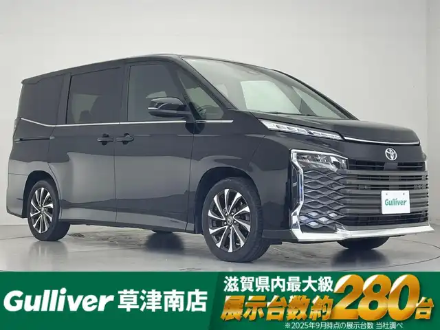 トヨタ ヴォクシー S－Z 滋賀県 2022(令4)年 4.5万km アティチュードブラックマイカ 純正8インチナビ/【Bluetooth/CD/DVD/フルセグTV】/純正フリップダウンモニター/両側パワースライドドア/ハーフレザーシート/バックカメラ/追従クルーズコントロール/クリアランスソナー/レーントレーシングアシスト/プリクラッシュセーフティ/LEDヘッドライト/オートマチックハイビーム/D/Nシートヒーター/ビルトインETC2.0/電動パーキングブレーキ/オートブレーキホールド/MTモード付AT/社外フロアマット/後席ロールサンシェード/プッシュスタート/スマートキー/ステアリングリモコン