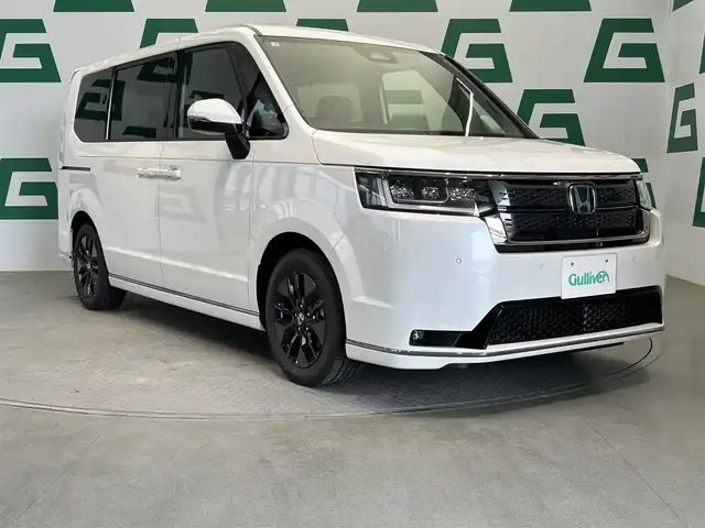 ホンダ ステップワゴン スパーダ eHEV 鹿児島県 2025(令7)年 0.1万km未満 プラチナホワイトパール 登録済未使用車/ホンダセンシング/・衝突軽減ブレーキ/・誤発進抑制機能（前後）/・歩行者事故低減ステアリング/・路外逸脱抑制機能/・渋滞追従機能付アダプティブクルーズコントロール/・車線維持支援システム/・渋滞運転支援機能/・先行車発進お知らせ機能/・標識認識機能/・オートハイビーム/・パーキングセンサーシステム/ブラインドスポットインフォメーション/アダプティブドライビングビーム/純正11インチメモリナビ【LXM-247VFLi】/（CD/DVD/フルセグ/Bluetooth/SD/USB）/バックカメラ/ハーフレザーシート/前席シートヒーター/2列目オットマン/全列USBチャージャー/革巻きステアリング/ステアリングリモコン/パドルシフト/電動パーキングブレーキ/ブレーキホールド/純正LEDヘッドライト/フロントフォグランプ/オートライト/ヘッドライトレベライザー/純正16インチアルミ/保証書&取扱説明書