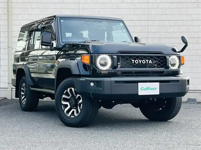 トヨタ ランドクルーザー AX 大分県 2023(令5)年 0.4万km アティチュードブラックマイカ 7インチベーシックナビ(NMZK-W73D)/【Bluetooth/フルセグ/DVD/CD/SD】/Toyota Safety Sense/・プリクラッシュセーフティ/・レーンディパーチャーアラート/・オートマチックハイビーム/・ロードサインアシスト/・発進遅れ告知機能/走行支援/・EBD付ABS&ブレーキアシスト/・VSC＆アクティブトラクションコントロール（A-TRC）/・ドライブスタートコントロール/・ヒルスタートアシストコントロール（HAC）/・ダウンヒルアシストコントロール（DAC）/・クルーズコントロール（定速制御のみ）/AUTHOR ALARM(スペア有)/充電用USB端子（Type-C/フロント2個）/自動防眩インナーミラー（バックモニター内蔵）/ハーフレザー(合成皮革＋ファブリック)/LEDヘッドランプ/バンパー埋込式LEDフロントフォグランプ/パートタイム4WD/電動デフロック（フロント/リヤ）/電動リモコンドアミラー/本革巻き4本スポークステアリング（木目調）/純正前後方ドライブレコーダー/バックカメラ/ETC2.0/純正ドアバイザー/純正フロアマット/スマートキー2本/メカニカルキー3本/保証書/取扱説明書