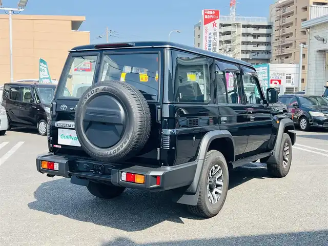 トヨタ ランドクルーザー AX 大分県 2023(令5)年 0.4万km アティチュードブラックマイカ 7インチベーシックナビ(NMZK-W73D)/【Bluetooth/フルセグ/DVD/CD/SD】/Toyota Safety Sense/・プリクラッシュセーフティ/・レーンディパーチャーアラート/・オートマチックハイビーム/・ロードサインアシスト/・発進遅れ告知機能/走行支援/・EBD付ABS&ブレーキアシスト/・VSC＆アクティブトラクションコントロール（A-TRC）/・ドライブスタートコントロール/・ヒルスタートアシストコントロール（HAC）/・ダウンヒルアシストコントロール（DAC）/・クルーズコントロール（定速制御のみ）/AUTHOR ALARM(スペア有)/充電用USB端子（Type-C/フロント2個）/自動防眩インナーミラー（バックモニター内蔵）/ハーフレザー(合成皮革＋ファブリック)/LEDヘッドランプ/バンパー埋込式LEDフロントフォグランプ/パートタイム4WD/電動デフロック（フロント/リヤ）/電動リモコンドアミラー/本革巻き4本スポークステアリング（木目調）/純正前後方ドライブレコーダー/バックカメラ/ETC2.0/純正ドアバイザー/純正フロアマット/スマートキー2本/メカニカルキー3本/保証書/取扱説明書