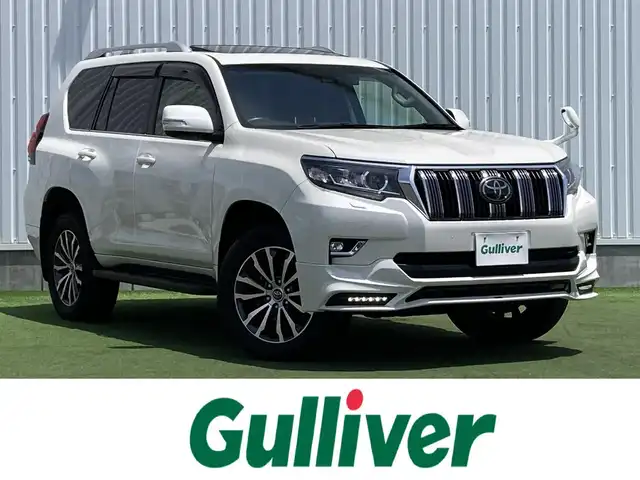 トヨタ ランドクルーザー プラド TX Lパッケージ 香川県 2019(令1)年 8万km ホワイトパールクリスタルシャイン 登録時走行距離：79972km/ディーラー純正9型ナビ/　CD DVD BT フルセグTV/バックカメラ/サンルーフ/TRDエアロ（フロント・リアアンダー）/オプション19インチアルミ/ブラックレザーシート/シートヒーター/エアシート/パワーシート/プリクラッシュセーフティシステム/レーンキープアシスト/レーダークルーズコントロール/ダウンヒルアシストコントロール/クリアランスソナー/ビルトインETC/ドライブレコーダー/MTモード付AT/横滑り防止装置/4WD/ディーゼルターボ/LEDヘッドライト/オートライト/フォグランプ/木目革巻きコンビステアリング/ステアリングスイッチ/プッシュスタート/スマートキー/スペアキー
