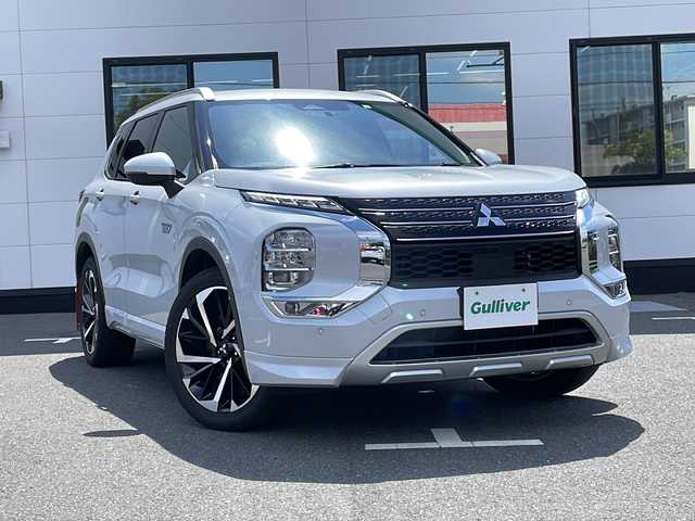 三菱 アウトランダー ＰＨＥＶ G 山口県 2022(令4)年 2.6万km ホワイトダイヤモンド 純正スマートフォン連携ナビ/・フルセグテレビ/・Bluetooth/・AM/FM/ワンオーナー/マルチアラウンドモニター/パワーバックドア/ヘッドアップディスプレイ/プラグインハイブリッド/スマートキー/プッシュスタート/クルーズコントロール（追従あり）/電動パーキングブレーキ/シートヒーター/ステアリングヒーター/パドルシフト/ルーフレール/シガーソケット/USB充電ポート/type-Cソケット×３/ペダルオペレーションモード/安全装置/・FCMブレーキアシスト/・誤発進抑制機能/・エマージェンシーストップシグナルシステム /マッドガード/リアバンパープロテクター