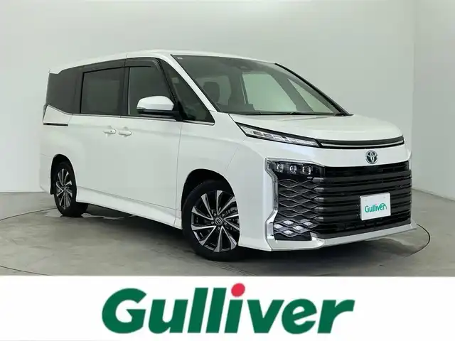 トヨタ ヴォクシー ハイブリッド S－Z 富山県 2023(令5)年 1.1万km ホワイトパールクリスタルシャイン 純正10.5型ディスプレイオーディオ/（AMFM/DVD/BT/USB/フルセグ）/バックカメラ/ドライブレコーダー/ETC/デジタルインナーミラー/ヘッドアップディスプレイ/両側パワースライドドア/オートホールド付電子パーキング/ハーフレザーシート/D/N席シートヒーター/快適温熱シート/衝突被害軽減システム/レーダークルーズコントロール/レーンキープアシスト/コーナーセンサー/横滑り防止装置/オートLEDライト/オートマチックハイビーム/純正アルミホイール/純正フロアマット/革巻きステアリング/ステアリングスイッチ/スマートキー/スペアキー